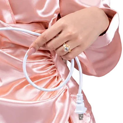 Detalle: mano con anillo sobre la blusa de satén rosa