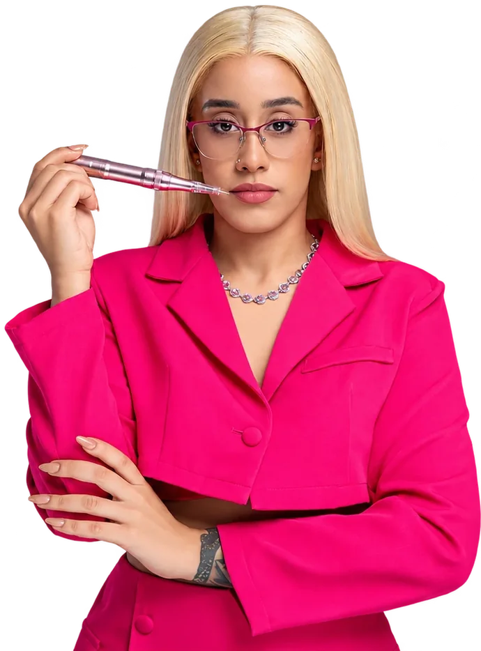 Profesional de Yaya Beauty Studio con traje fucsia y gafas, sosteniendo un dermógrafo de micropigmentación