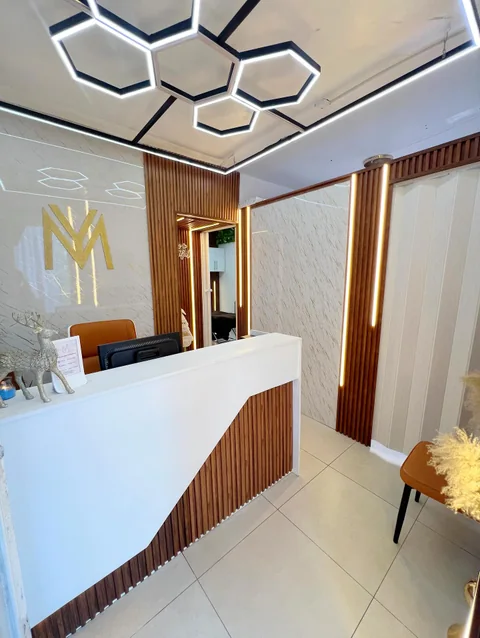 Recepción de Yaya Beauty Studio con el monograma dorado en la pared
